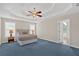 Primary bedroom with tray ceiling, carpet, and ensuite bathroom access at 1715 Branchwood Ct, Powder Springs, GA 30127