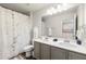 Well-lit bathroom with double sink vanity, decorative shower curtain and modern fixtures at 1947 Thomasville Estate Dr, Atlanta, GA 30315