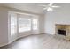 Bright living room featuring a stone fireplace, vaulted ceiling, and large windows at 1345 Smoke Hill Dr, Hoschton, GA 30548