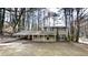 Traditional two story home with covered porch and driveway, surrounded by mature trees at 2134 Elinwood Dr, Atlanta, GA 30344