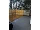 Fenced backyard with wooden deck, concrete pad, and mature trees offering shade at 3523 Lehigh Way, Decatur, GA 30034