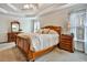 Comfortable bedroom with tray ceilings, carpet, and a large wooden bed frame at 5712 Overlook Cir, Powder Springs, GA 30127