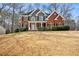 A stunning two-story brick home with a green accent has manicured landscaping, and a well-maintained lawn at 5712 Overlook Cir, Powder Springs, GA 30127