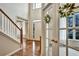 Grand foyer with hardwood floors, staircase and French doors leading into a sunlit living area at 5712 Overlook Cir, Powder Springs, GA 30127