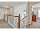 Bright upstairs hallway with wooden railing and modern light fixture, leading to bedrooms at 5712 Overlook Cir, Powder Springs, GA 30127