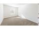 Empty bedroom featuring neutral carpet, bright walls, one window, and a door at 7477 Caribou Trl, Riverdale, GA 30296