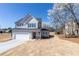 Charming two-story home with gray siding, manicured lawn, and an attached two-car garage at 7477 Caribou Trl, Riverdale, GA 30296