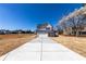 Inviting two-story home featuring a long concrete driveway leading to an attached two-car garage at 7477 Caribou Trl, Riverdale, GA 30296