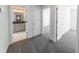 Hallway view into a bathroom with gray cabinets and a mirror under a light fixture at 7477 Caribou Trl, Riverdale, GA 30296