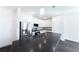 Modern kitchen featuring white cabinetry, stainless steel appliances, and a dark countertop island at 7477 Caribou Trl, Riverdale, GA 30296