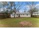 This is a grass-covered backyard and home exterior view, with a wood fence at 3169 Bluebird Ln, Decatur, GA 30032