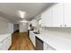 Open kitchen boasts white cabinets, stone countertops, and stainless steel dishwasher at 4481 Buckingham Cir, Decatur, GA 30035