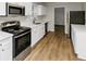 Bright kitchen features stainless steel appliances, white cabinetry, and wood-look flooring at 4481 Buckingham Cir, Decatur, GA 30035