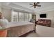 Relaxing main bedroom with seating area, tray ceiling, leather sofa, and large windows at 104 Edgewater Trl, Canton, GA 30115