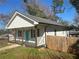 Inviting home with a covered porch, white siding, dark shutters, a bright blue front door, and a grassy front yard at 937 Camilla Sw St, Atlanta, GA 30314
