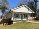 Charming home with a covered porch, white siding, dark shutters, and a bright blue front door at 937 Camilla Sw St, Atlanta, GA 30314
