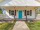Charming front porch features a vibrant teal door, wooden beams, and rustic shutters at 937 Camilla Sw St, Atlanta, GA 30314
