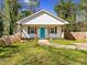 A quaint home with a well-kept lawn, a white exterior, and a cheerful teal front door at 937 Camilla Sw St, Atlanta, GA 30314