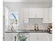 Bright kitchen featuring white cabinets, stainless steel appliances, and a stylish backsplash at 937 Camilla Sw St, Atlanta, GA 30314