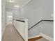 Upstairs hallway with neutral carpet and paint, white trim, and black railing at 1583 Mosaic Way, Smyrna, GA 30080
