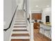 Elegant staircase leading to the upper level, with views of the kitchen and breakfast bar at 1583 Mosaic Way, Smyrna, GA 30080