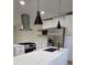 Modern kitchen featuring white countertops, stainless steel appliances, stylish lighting, and a sleek exhaust hood at 2371 Cresta Dr, Decatur, GA 30032