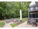 A backyard with an outdoor kitchen, fire pit, and a covered seating area on a stone patio at 281 Laney Dr, Locust Grove, GA 30248