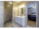 Well-lit bathroom with a single vanity, tile floors, and an adjacent bedroom at 281 Laney Dr, Locust Grove, GA 30248