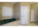 Bright bathroom featuring a jetted tub, tiled floors and walls, and a linen cabinet at 281 Laney Dr, Locust Grove, GA 30248