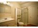 Bright bathroom featuring a vanity, toilet, and a glass-enclosed shower, all in a clean, neutral color palette at 281 Laney Dr, Locust Grove, GA 30248