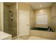 Relaxing bathroom featuring a jetted tub, tiled floors and walls, and a glass-enclosed shower at 281 Laney Dr, Locust Grove, GA 30248