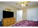 This bedroom includes a ceiling fan, hardwood floors, a door to another room, and a dresser at 281 Laney Dr, Locust Grove, GA 30248