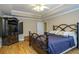 Serene bedroom featuring hardwood floors, a decorative bed frame, and an entertainment center at 281 Laney Dr, Locust Grove, GA 30248