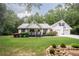 Charming home featuring a metal roof, inviting front porch, landscaping, and a two-car garage with basketball hoop at 281 Laney Dr, Locust Grove, GA 30248
