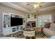 Inviting living room featuring a tray ceiling, ceiling fan, fireplace, and plush sofas at 281 Laney Dr, Locust Grove, GA 30248