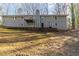 View of the back of the gray home showing a deck and retaining wall with large yard at 5845 Highway 92, Fairburn, GA 30213