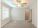 Carpeted bedroom with a ceiling fan, and a single window. Bathroom door is open at 5845 Highway 92, Fairburn, GA 30213