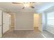 Carpeted bedroom featuring ceiling fan, and two open doors with closets and bathrooms at 5845 Highway 92, Fairburn, GA 30213