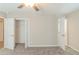 Carpeted bedroom featuring ceiling fan, and two open doors with closets at 5845 Highway 92, Fairburn, GA 30213