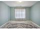 Light-filled bedroom with a window, light blue walls, and stylish floor coverings at 6844 Cavalier Ct, Stone Mountain, GA 30087