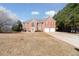 Charming two-story brick home with red shutters and attached two-car garage on a large lot at 6844 Cavalier Ct, Stone Mountain, GA 30087