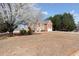 Charming two-story brick home with red shutters and attached two-car garage surrounded by trees and grass at 6844 Cavalier Ct, Stone Mountain, GA 30087