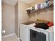 Efficient laundry room with modern washer and dryer, plus convenient overhead storage shelving at 6844 Cavalier Ct, Stone Mountain, GA 30087