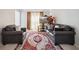 Comfortable living room with dark leather furniture, red rug, and floral accents at 6844 Cavalier Ct, Stone Mountain, GA 30087