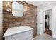 Stylish bathroom with exposed brick accent wall, marble vanity, and modern fixtures at 1116 Piedmont Ne Ave # 12, Atlanta, GA 30309