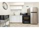 Efficient kitchen featuring black appliances, white cabinetry, and neutral tile flooring at 300 W Peachtree St # 8C, Atlanta, GA 30308