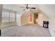 Large, carpeted bonus room with a ceiling fan, a window, and an entrance to the bathroom at 477 Glouchester Dr, Locust Grove, GA 30248