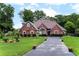 Beautiful brick home featuring a landscaped front yard, lush greenery, and a spacious driveway at 477 Glouchester Dr, Locust Grove, GA 30248