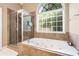 Bathroom with soaking tub, separate shower, and large window at 477 Glouchester Dr, Locust Grove, GA 30248