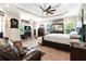 Spacious primary bedroom featuring a trey ceiling, ceiling fan, and a cozy seating area at 477 Glouchester Dr, Locust Grove, GA 30248